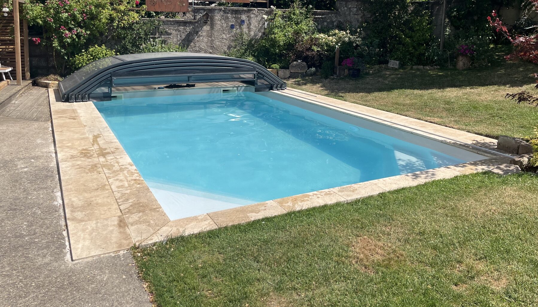 Abri de piscine Anséa ouvert, terrasse et margelles piscine coque grise, installation Peltre Metz
